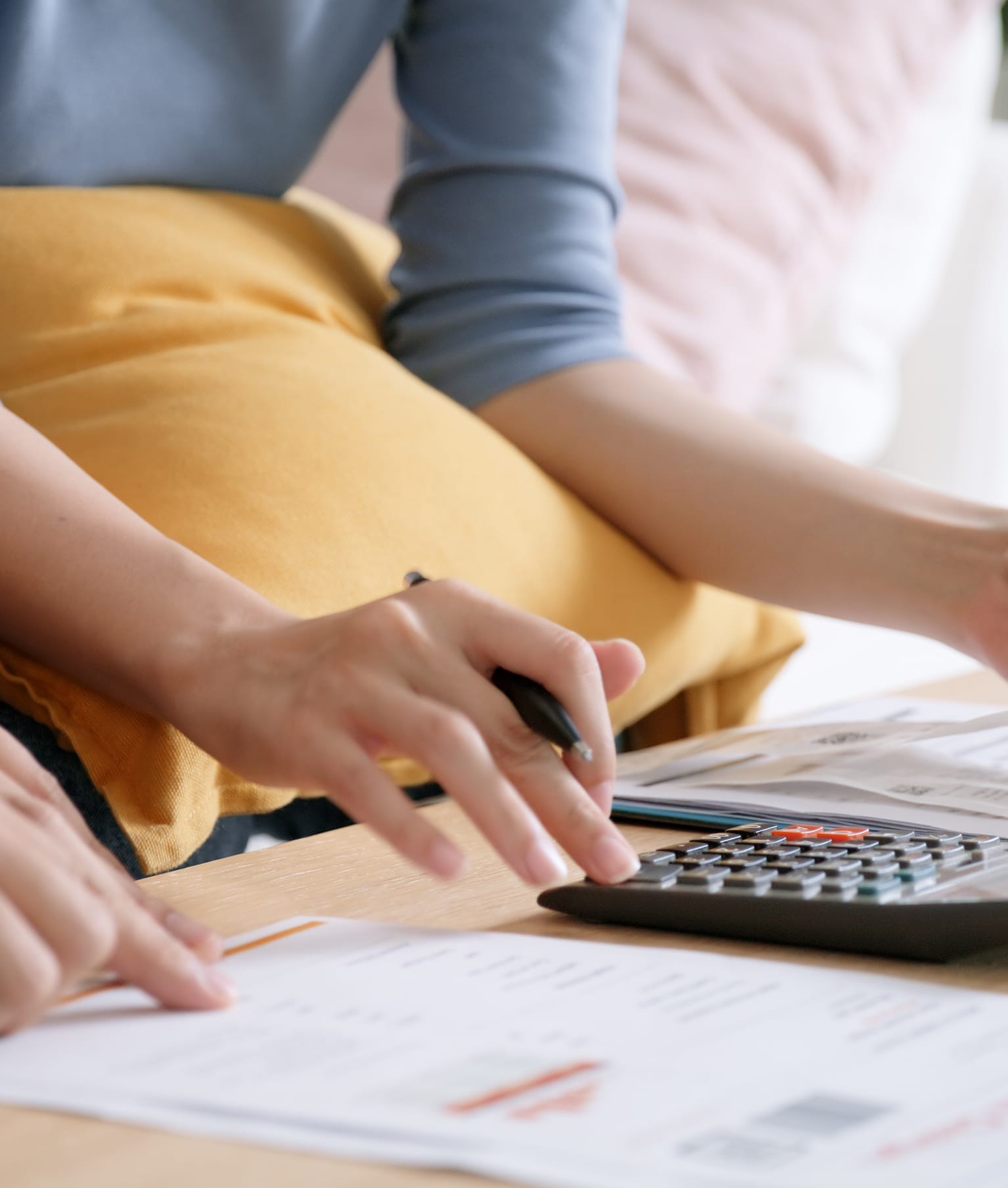 Un couple établit un budget à l’aide de documents et d’une calculatrice.  