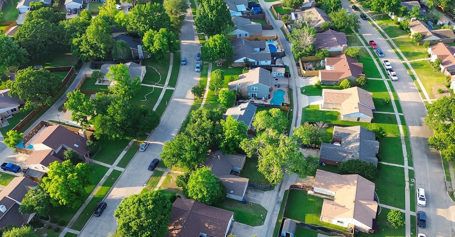 Vue aérienne d'un quartier résidentiel avec plusieurs maisons, illustrant l'évolution et les tendances de l'actualité immobilière 