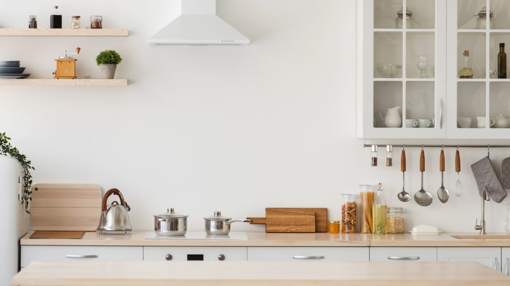 Small white kitchen with decorations on shelves