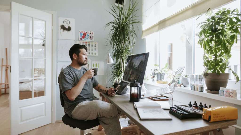 Une personne boit du café à un bureau à domicile