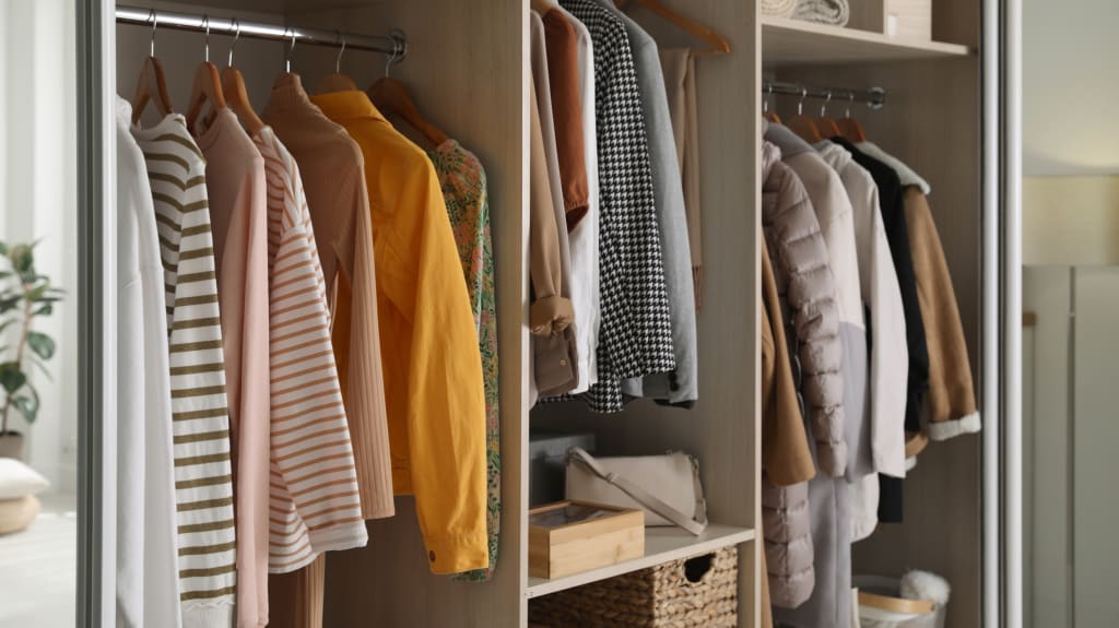 Penderie organisée avec des étagères et des vêtements suspendus