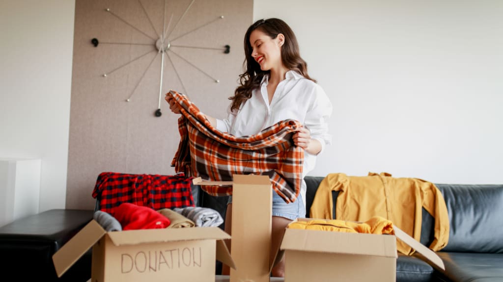 A woman sorting through clothes for donation