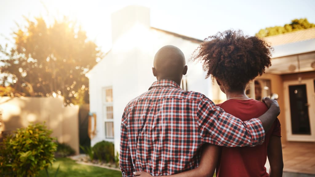 Couple regardant une maison de l'extérieur