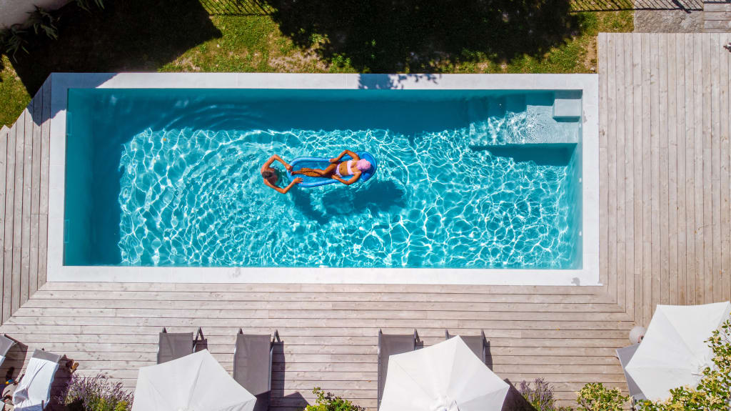 Two people swimming in a narrow rectangular pool