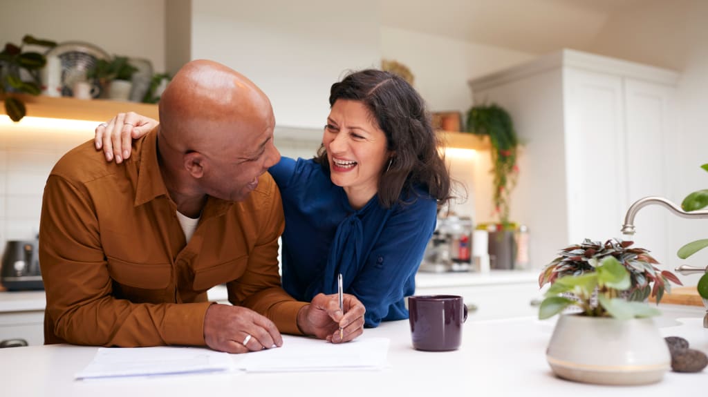 Couple laughing while signing papers