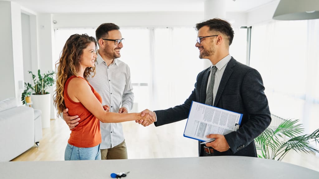 Couple shaking hands with a realtor