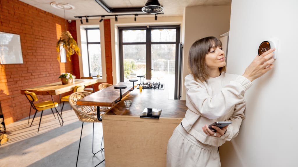 Femme ajustant le thermostat à la baisse