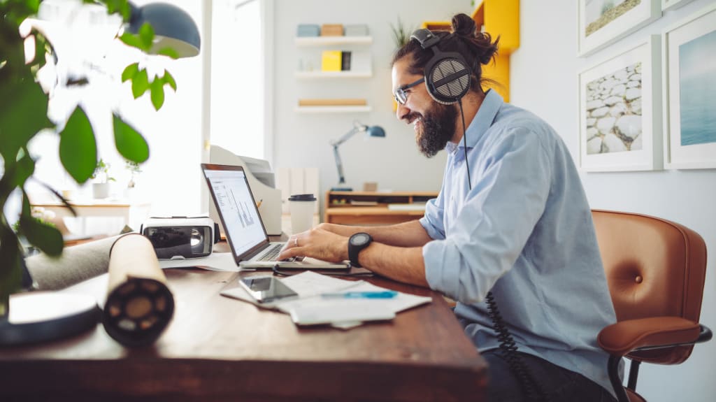 Working in front of a computer with headphones on