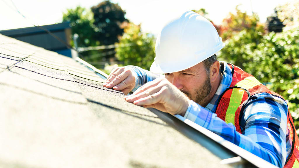 Building inspector assessing the condition of a roof during a pre-purchase inspection in Quebec