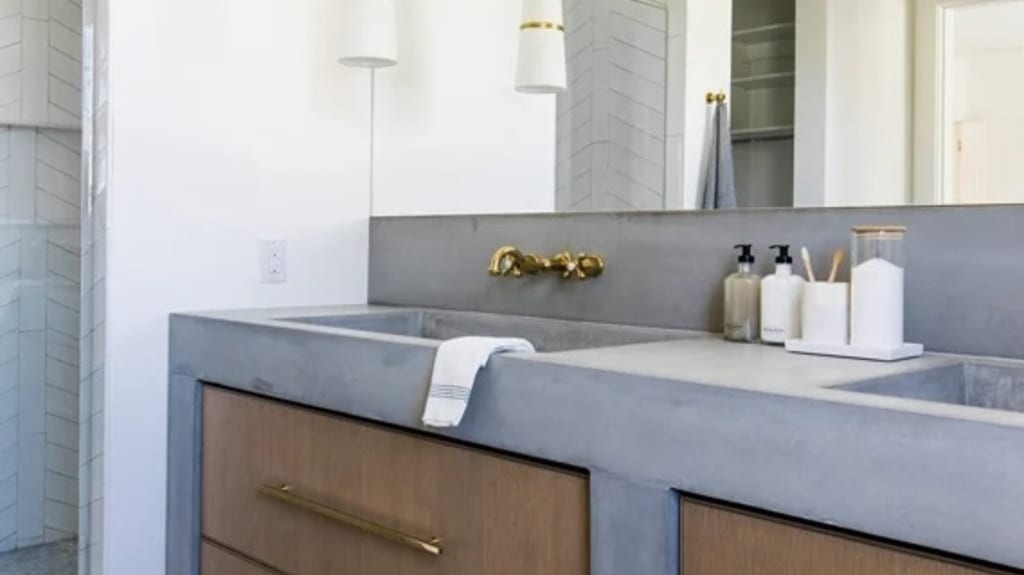 Une salle de bain moderne violet et blanc, avec des accents dorés et une douche en céramique