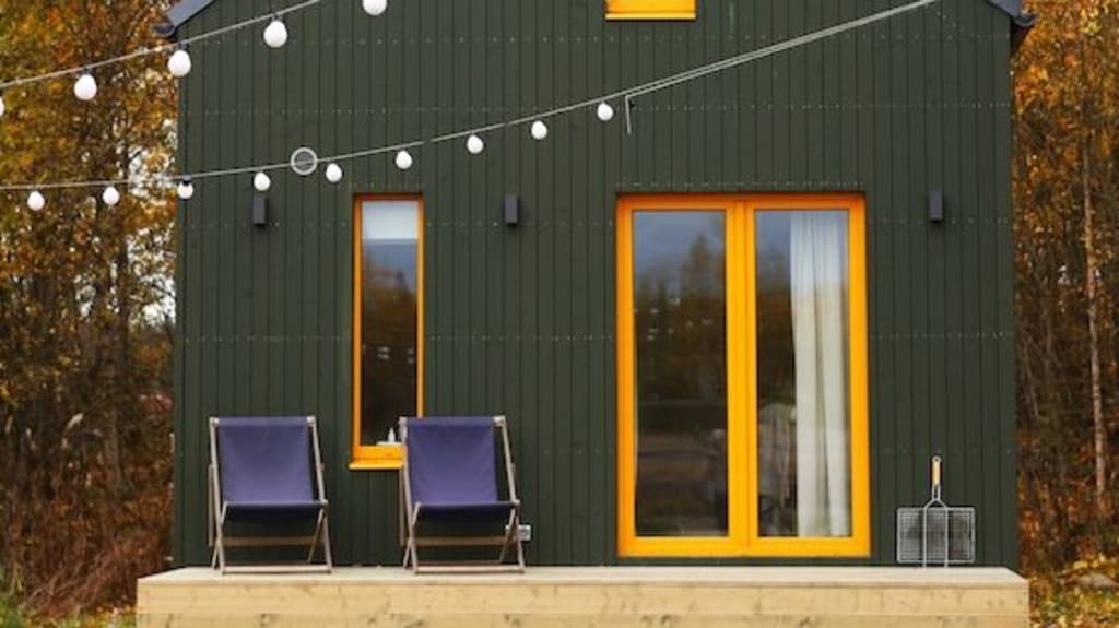 Minimaison verte avec un balcon