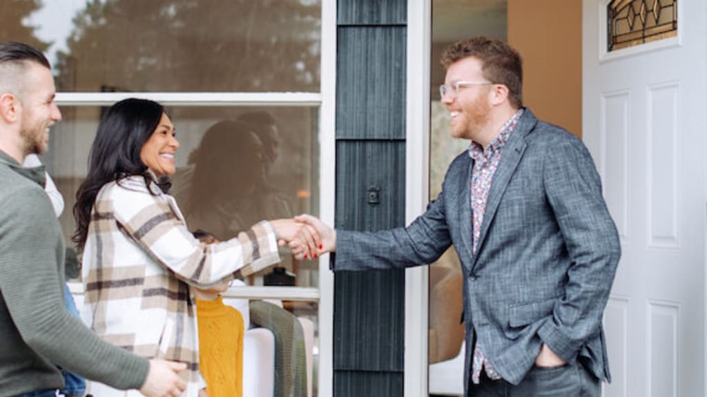 Buyers shaking the hand of a real estate agent