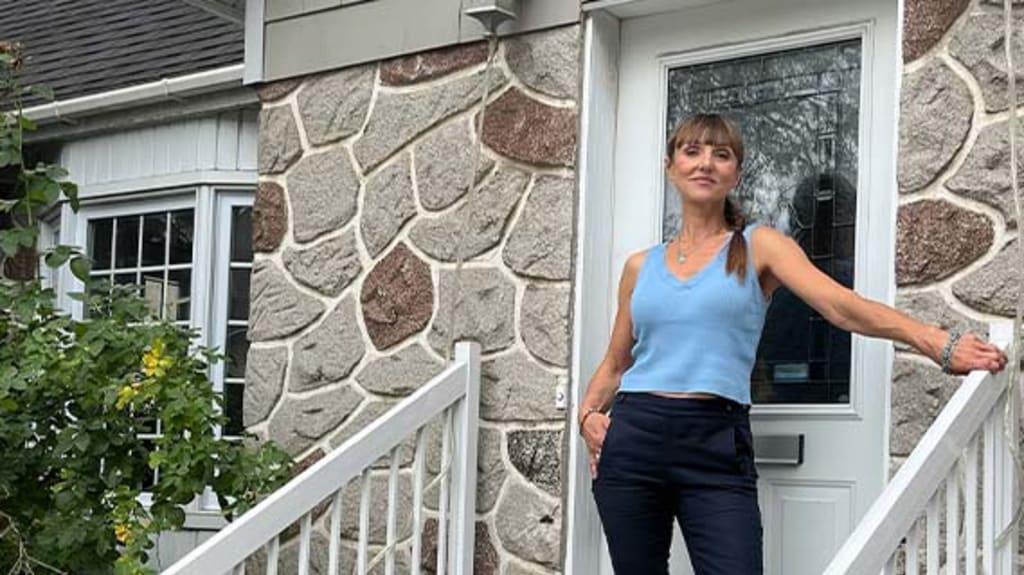 Iryna devant sa maison à vendre à Montréal
