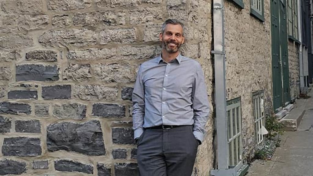 Louis-Philippe devant l'immeuble de son condo à vendre dans le Vieux-Québec