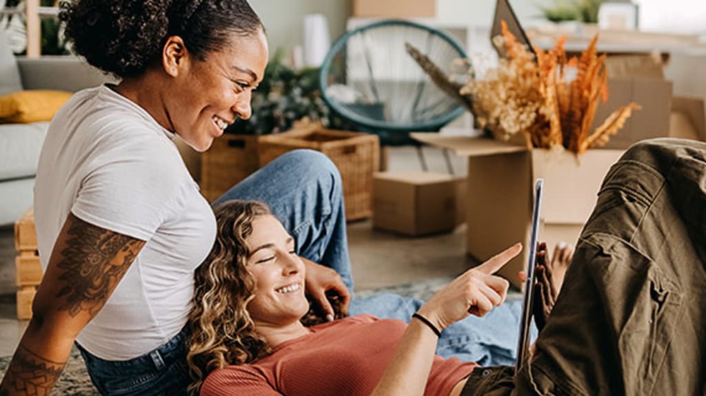 Two people in a living room looking at a document to learn everything about buying a property