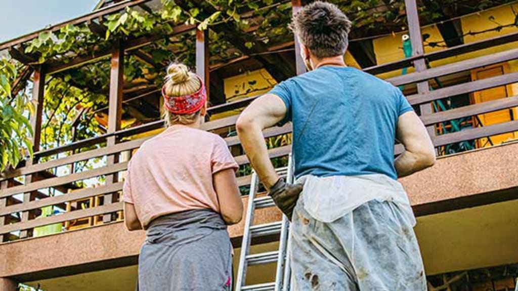 Couple effectuant l'entretien extérieur de leur propriété au printemps