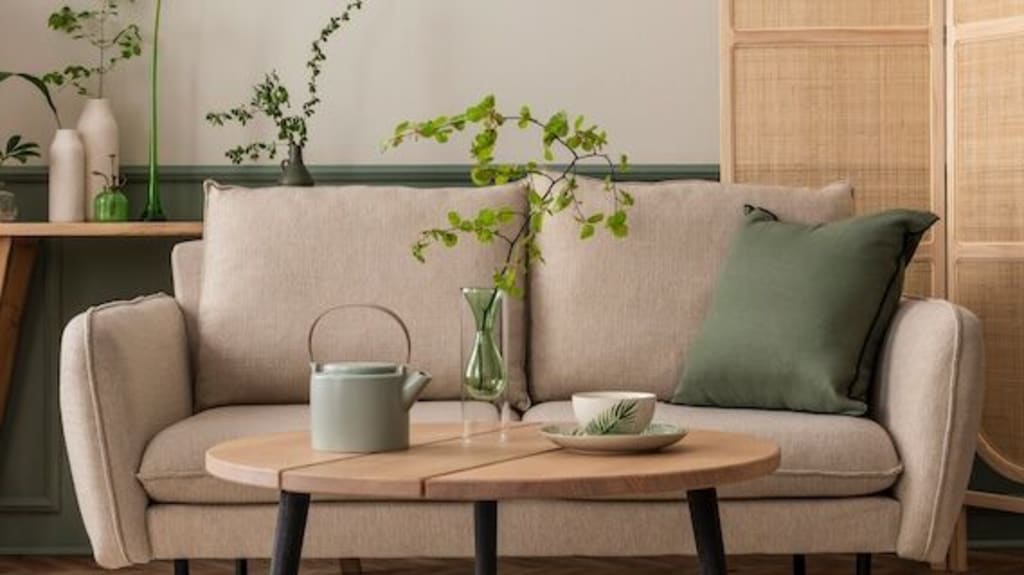 Salon d’une maison qui respecte les tendances et les styles 2025 avec canapé beige, table basse, mur de séparation et autres accessoires