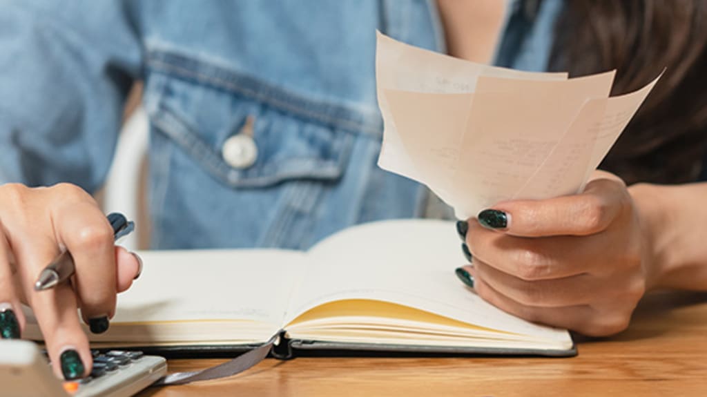 Femme calculant le montant de ses factures afin de gérer ses finances