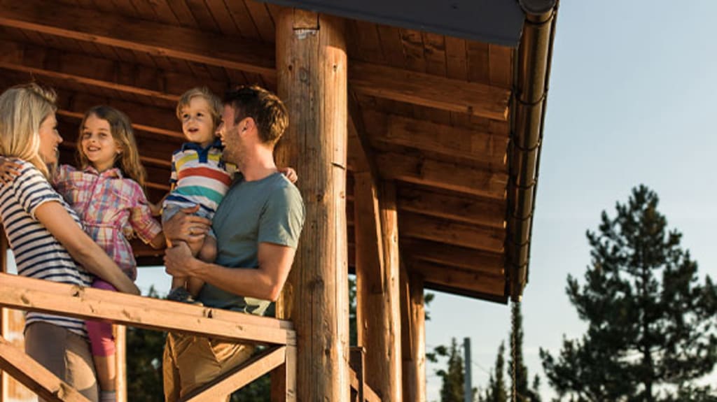 Famille sur le balcon de son chalet en forêt