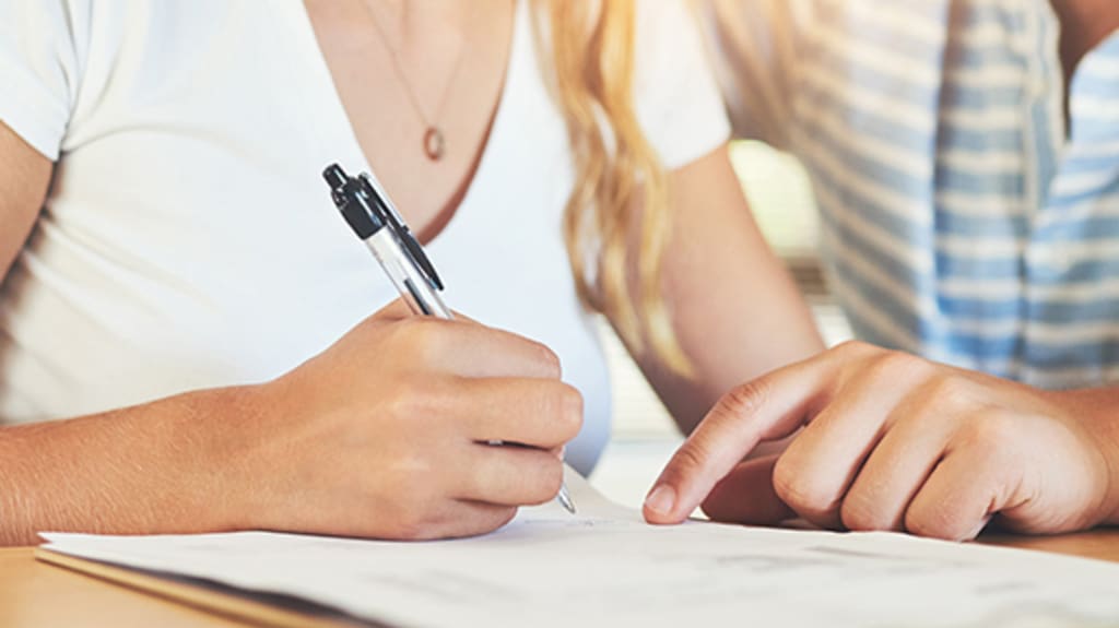 Couple smiling at each other and looking at a paper document to prepare to buy a house in a bidding war context
