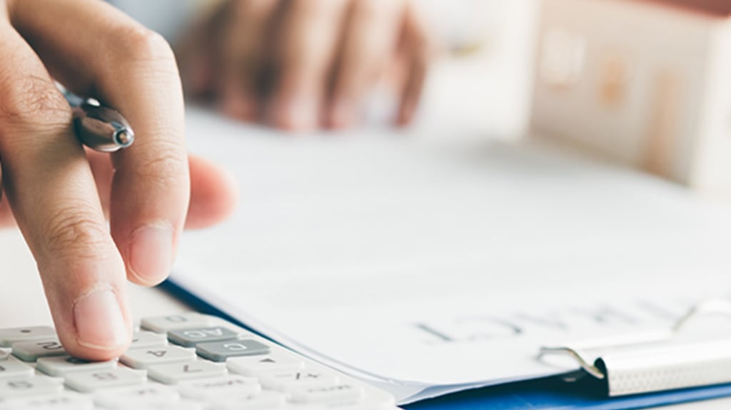 Main qui calcule le montant de l'assurance prêt hypothécaire