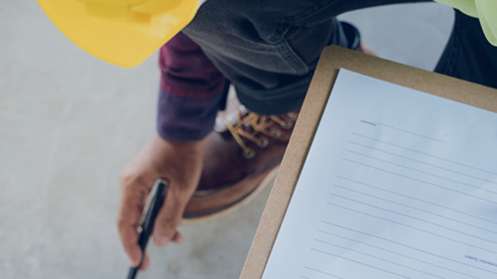 Contractor conducting an inspection with paper documents