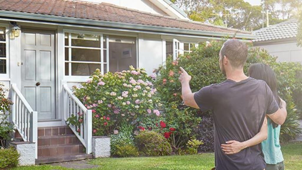 Couple standing in front of a property