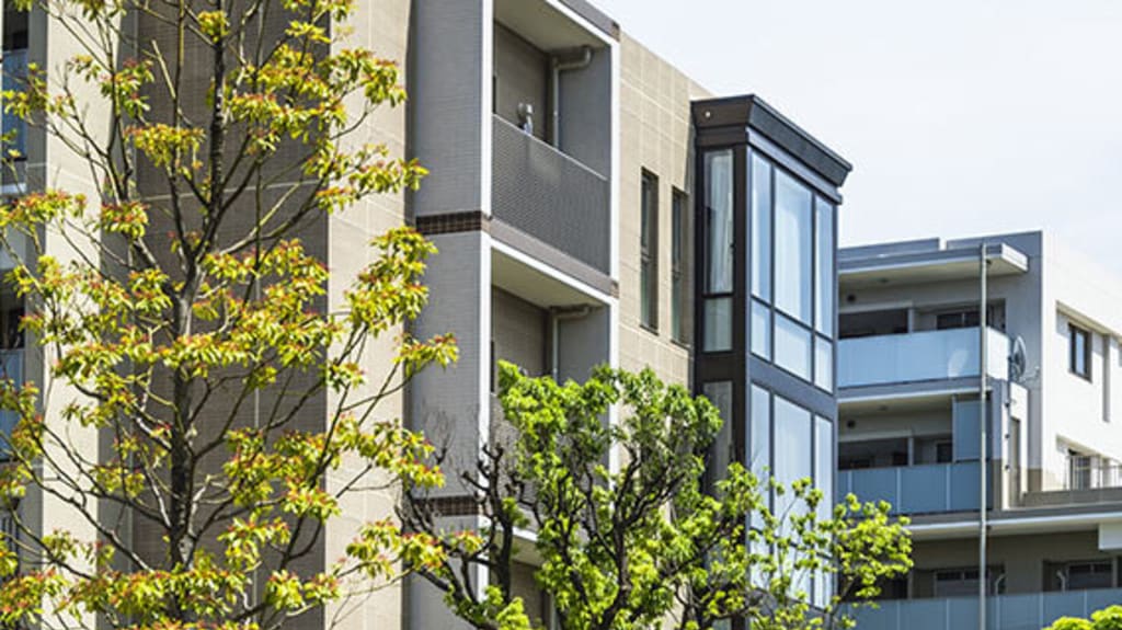 Vue sur des condos à acheter qui sont entourés d'arbres