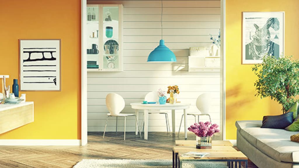 Vue sur le salon aux murs orangés d'une maison qui pourrait être louée sur un site de location