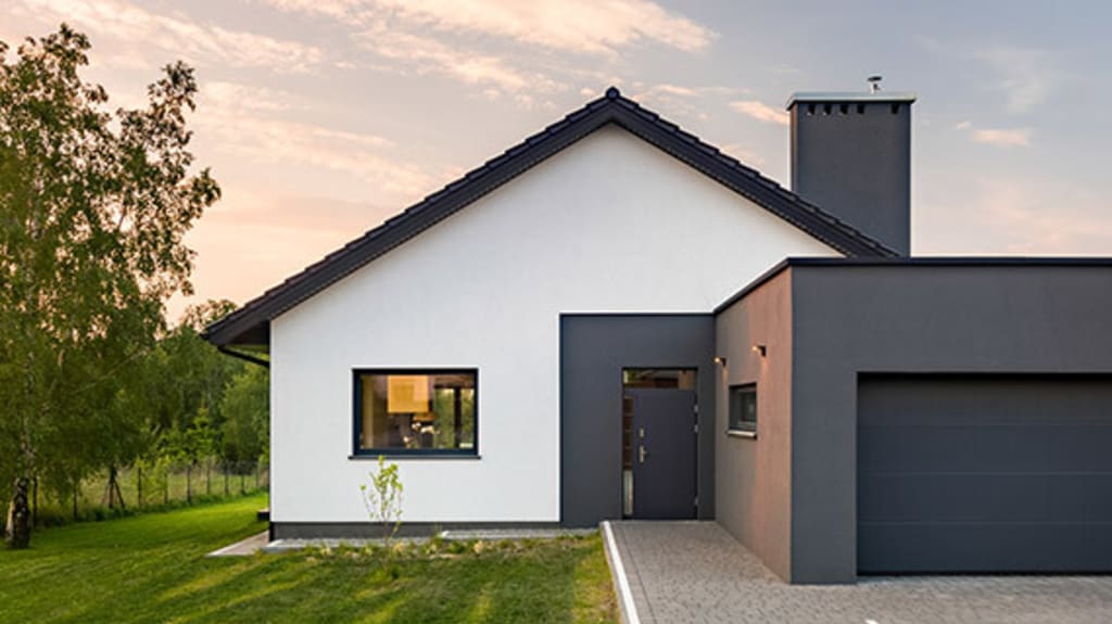Maison noire et blanche située sur un grand terrain en campagne