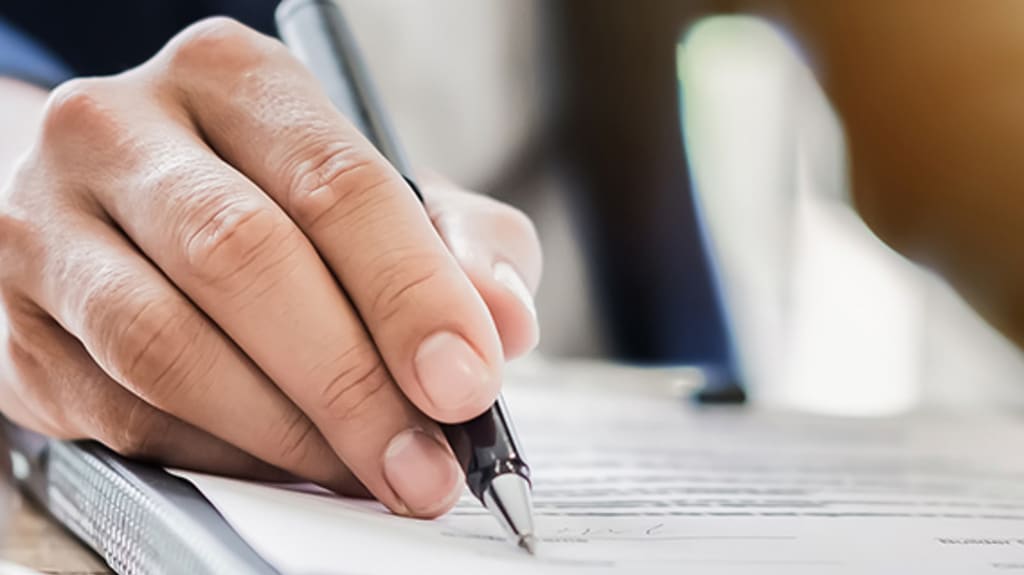 A notary signs a legal document during a home sale