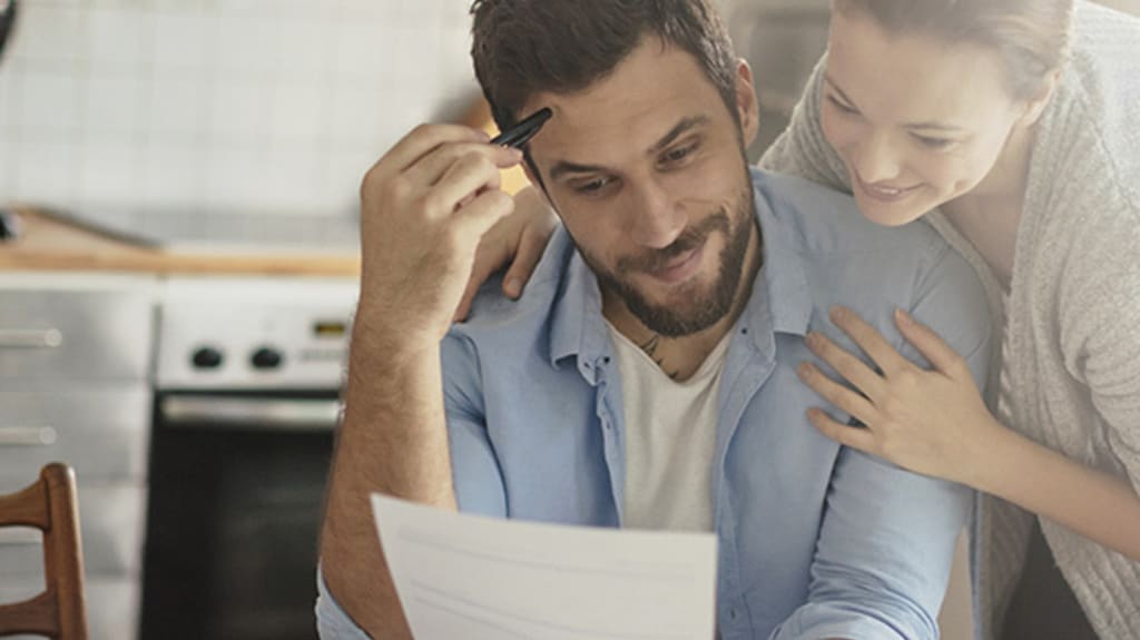 Un homme et une femme regardent avec attention un document