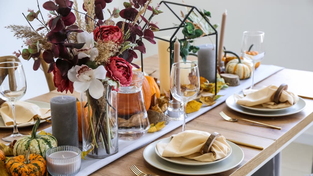 Belle table avec décorations d'automne, fleurs, citrouilles, chandelles et vaisselle assortie