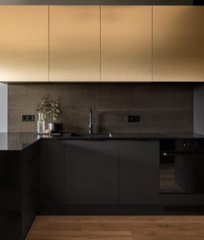 Intérieur de cuisine chic avec armoires dorées et comptoir noir