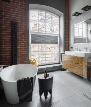 Salle de bain de style industriel avec mur de béton, mur de pierre et vanité flottante en bois