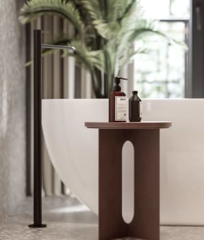 Produits de bain sur table en bois près d’une baignoire