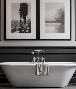 Bathroom in shades of grey with two frames above the bath 