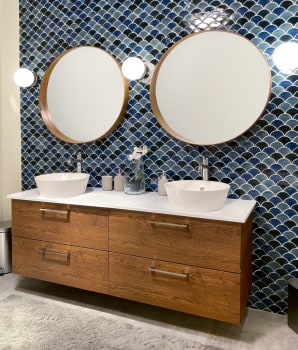 Bathroom with blue tiles on wall and floating wooden vanity 