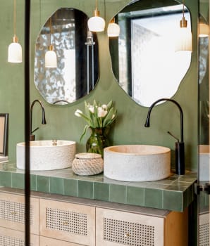 Bohemian-style bathroom interior with curved mirrors and pale wood accents 