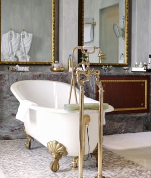 Antique clawfoot bathtub with gilded metal finishes 