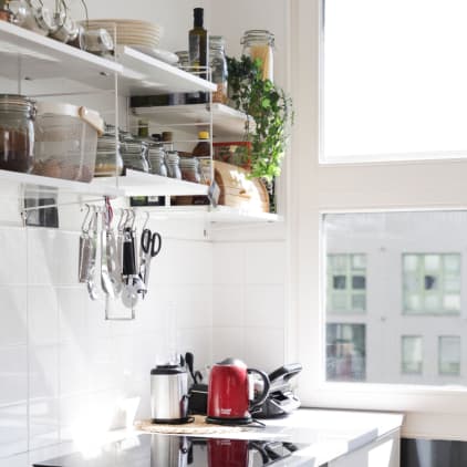 Bright kitchen with shelves and hanging utensils
