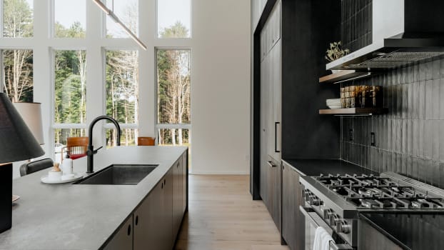 Armoires de cuisine et dosseret noirs, comptoir de granit gris
