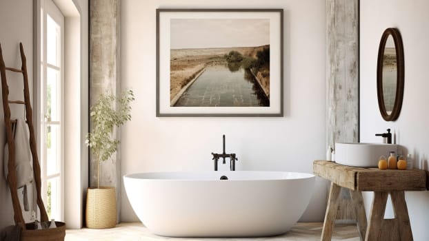 Intérieur d’une salle de bain avec matériaux naturels et cadre au-dessus de la baignoire