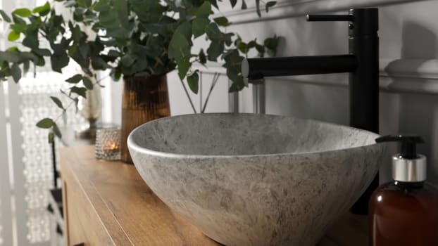 Branches d’eucalyptus près d’un lavabo sur un meuble de salle de bain