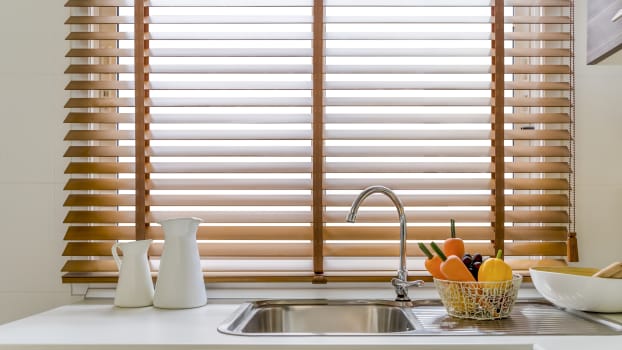 Wood blinds and sink in front of a window