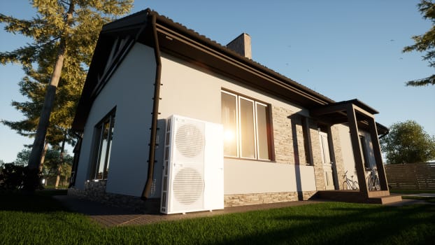 Pompe thermique installée devant une petite maison écologique moderne