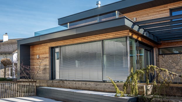 Propriété au design moderne et industriel avec revêtement en bois, grandes fenêtres et salle d'exposition