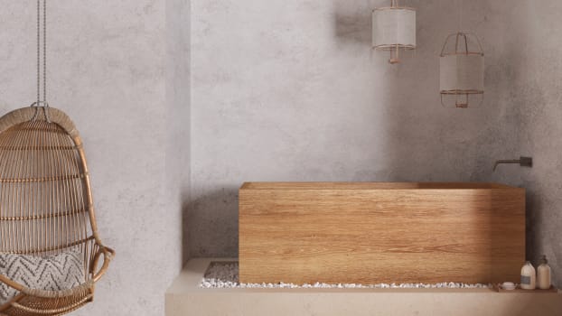Japandi bathroom with freestanding wooden bathtub, hanging armchair and concrete walls 