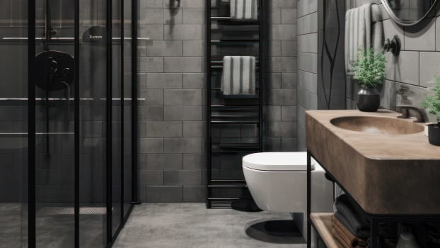 Interior of an industrial-style bathroom with gray ceramic tiles, vanity unit and metal finishes 