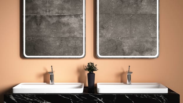 Black bathroom cabinet with veins and square mirrors on coral wall 